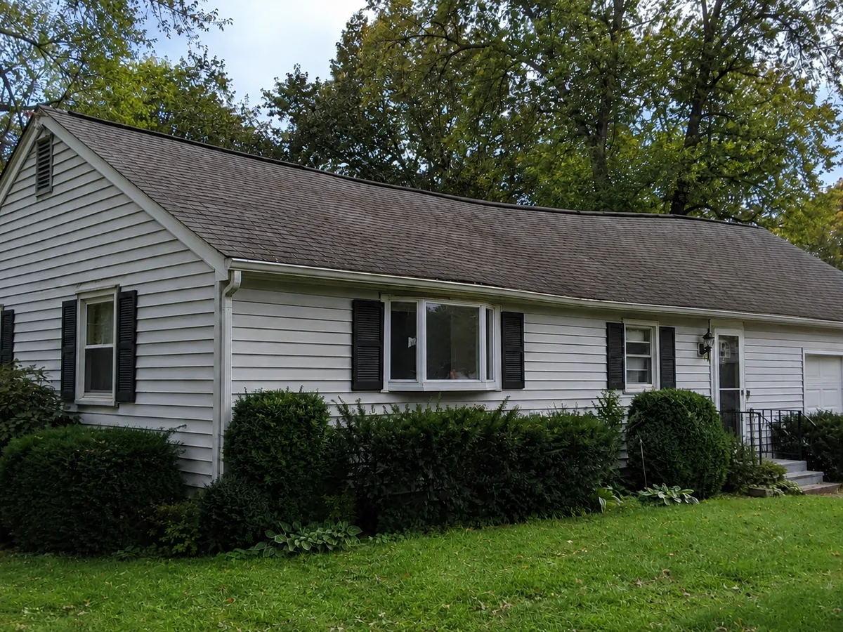 A house with a visibly dipped and wavy roofline instead of a straight ridge